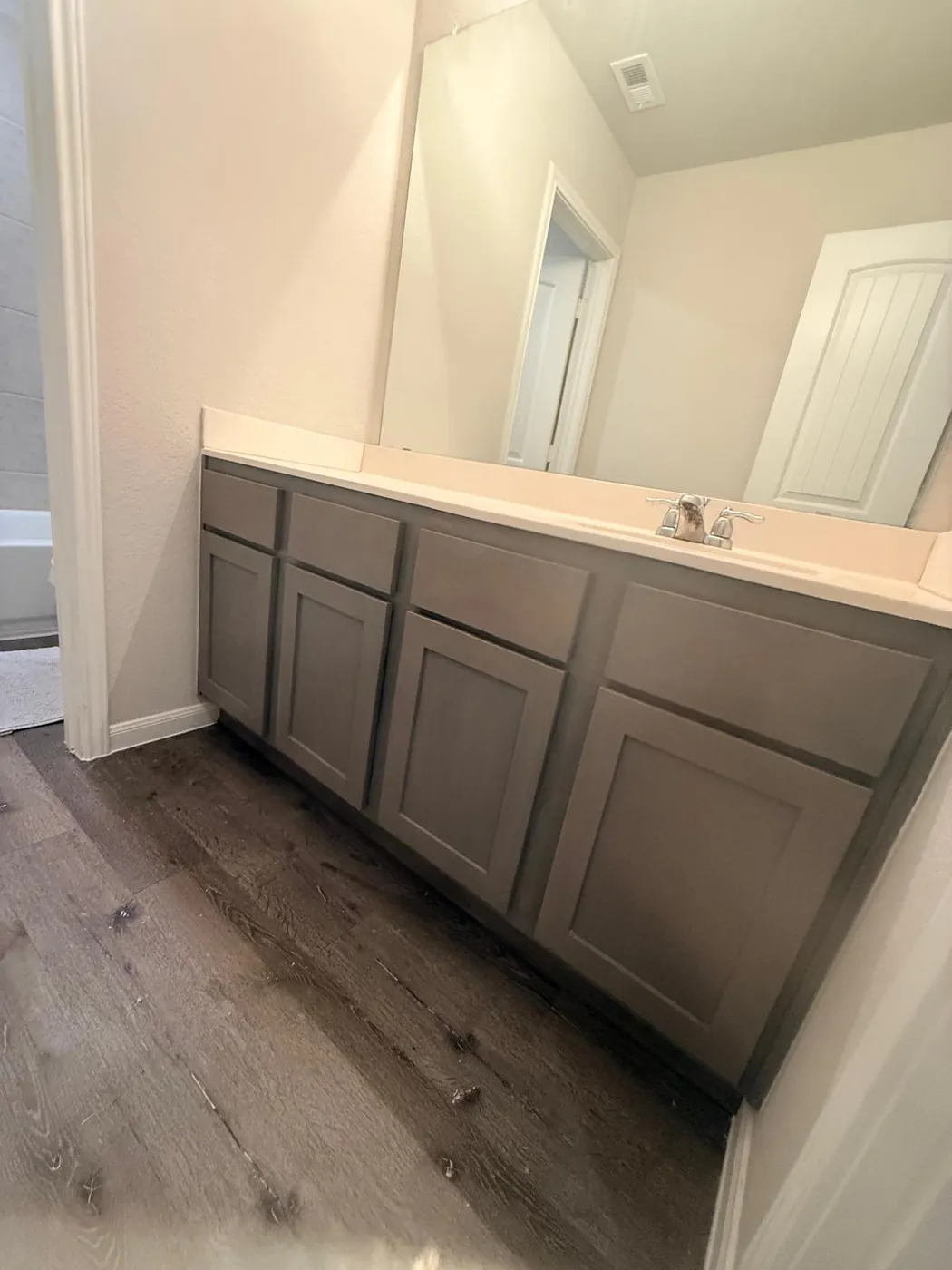 Gray double vanity set on new plank flooring.
