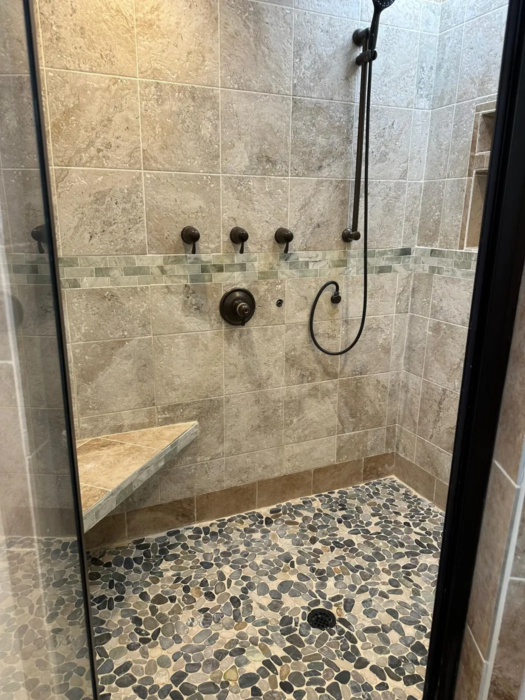 The same walk-in shower behind its new glass door.