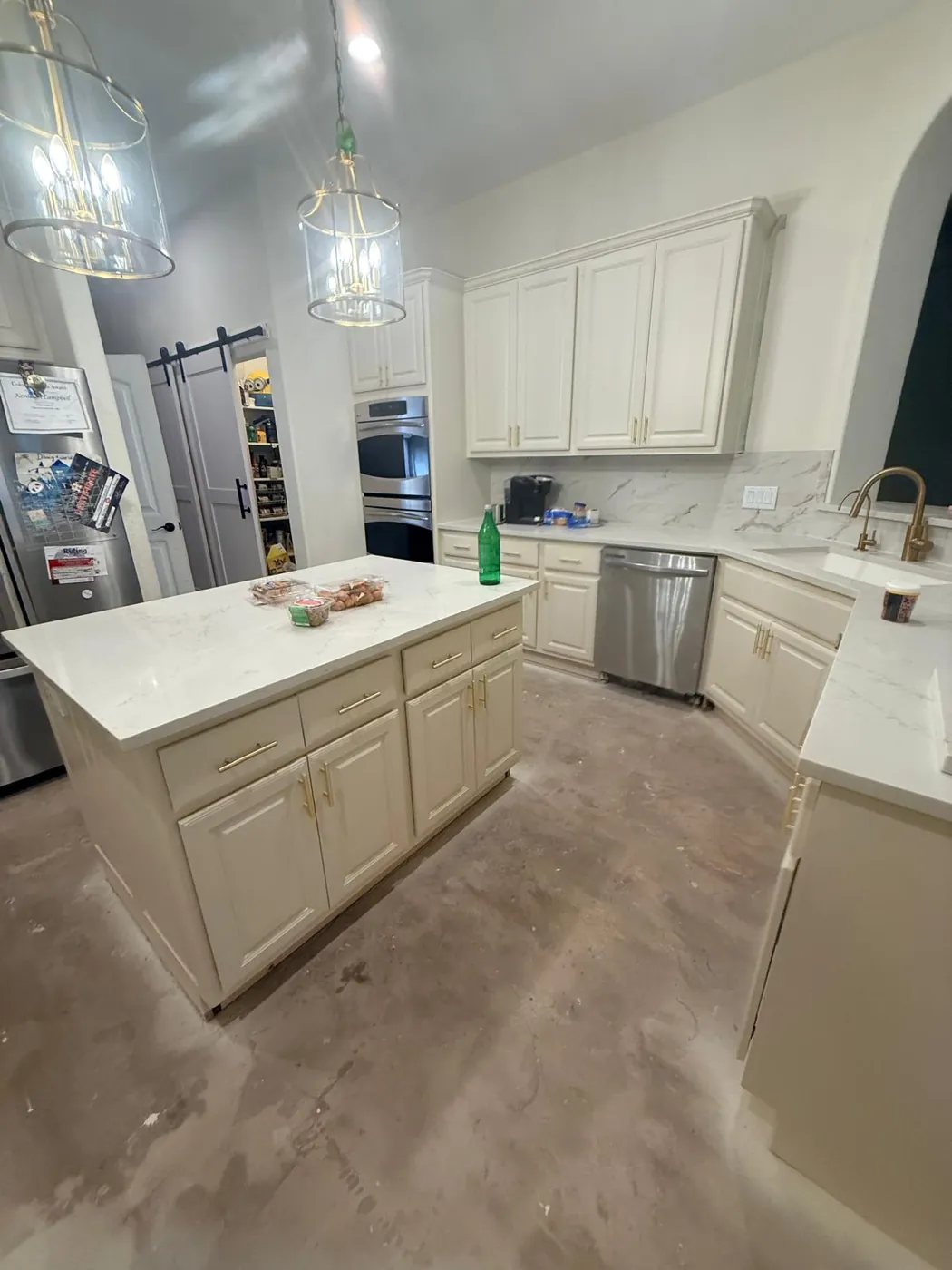 Island, pendants and a barn door — the kitchen opened up and finished.