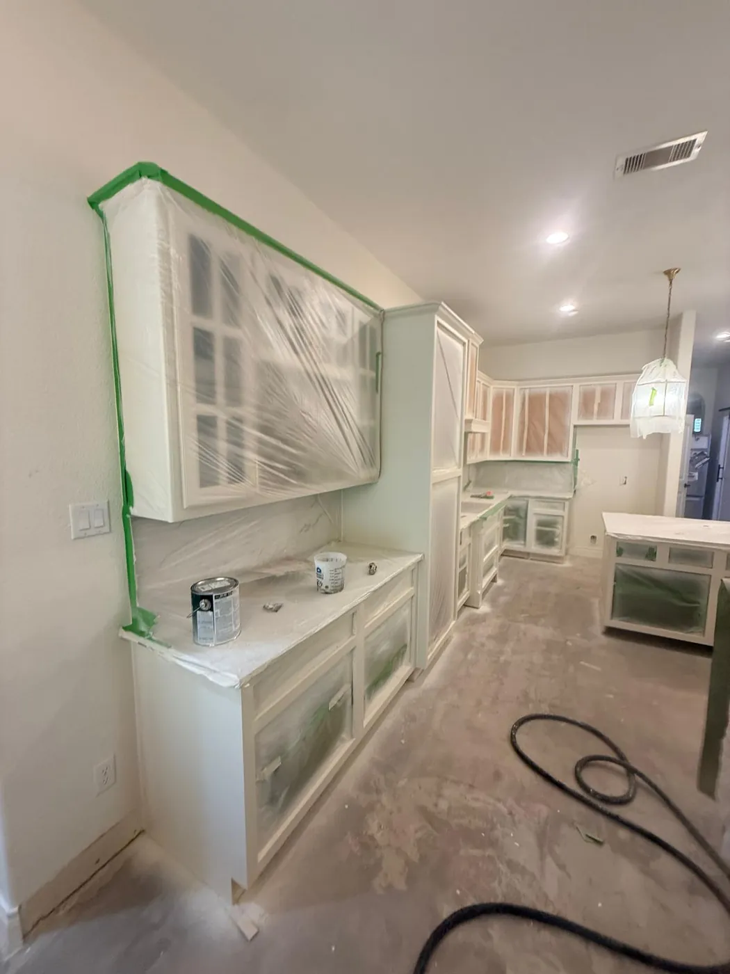 Glass cabinets taped and masked for a clean paint line.